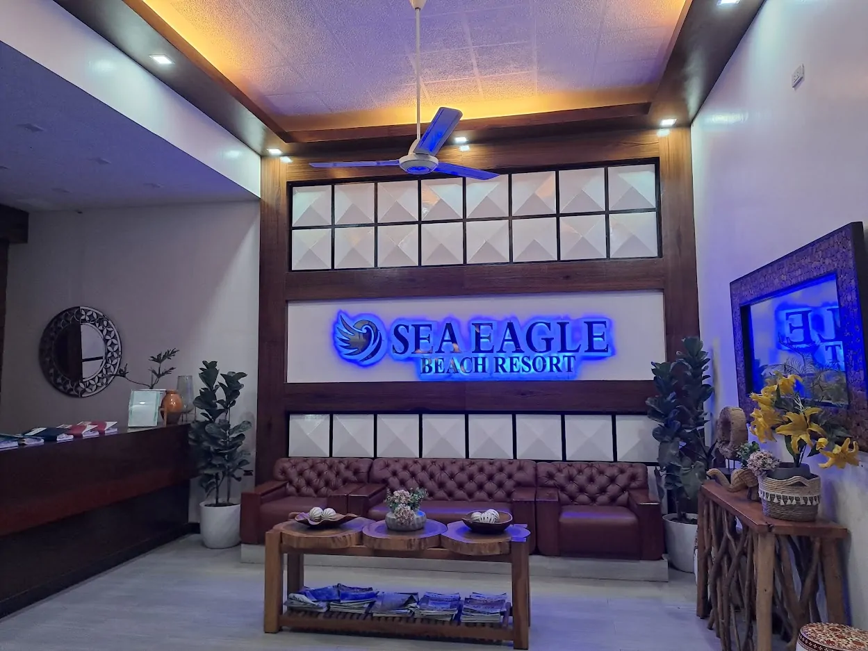 Native open cottages and picnic tables at Sea Eagle Beach Resort